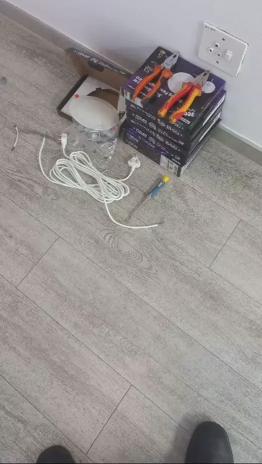 Electrical tools and LED panel lights on a wood-grain floor